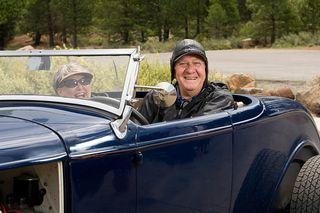 person driving an old fashioned car