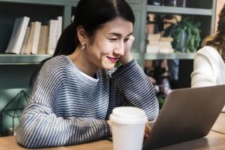 Woman staring at her laptop at a coffee shop