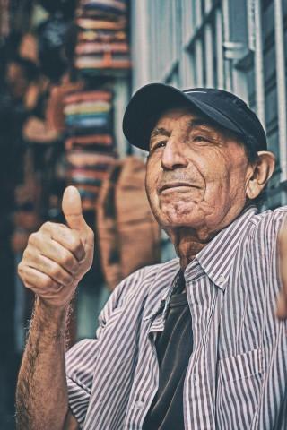 Elder man giving thumbs up to camera