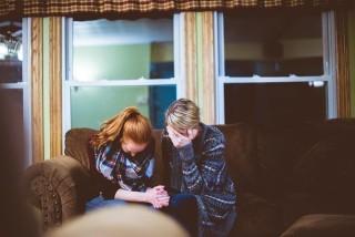 two women crying on a couch