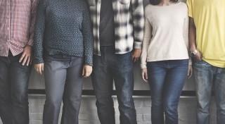 a row of people standing in a line, neck down