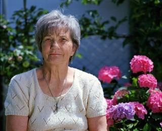 Elderly woman looking at camera in garden