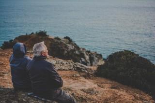 An old couple staring at ocean