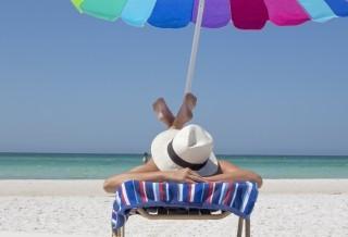 Woman sitting on a beach under umbrella