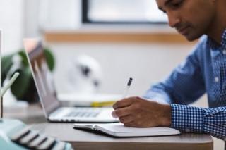 a man writing in a notebook