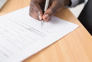A hand signing a contract
