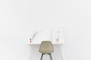 A white desk in a white room
