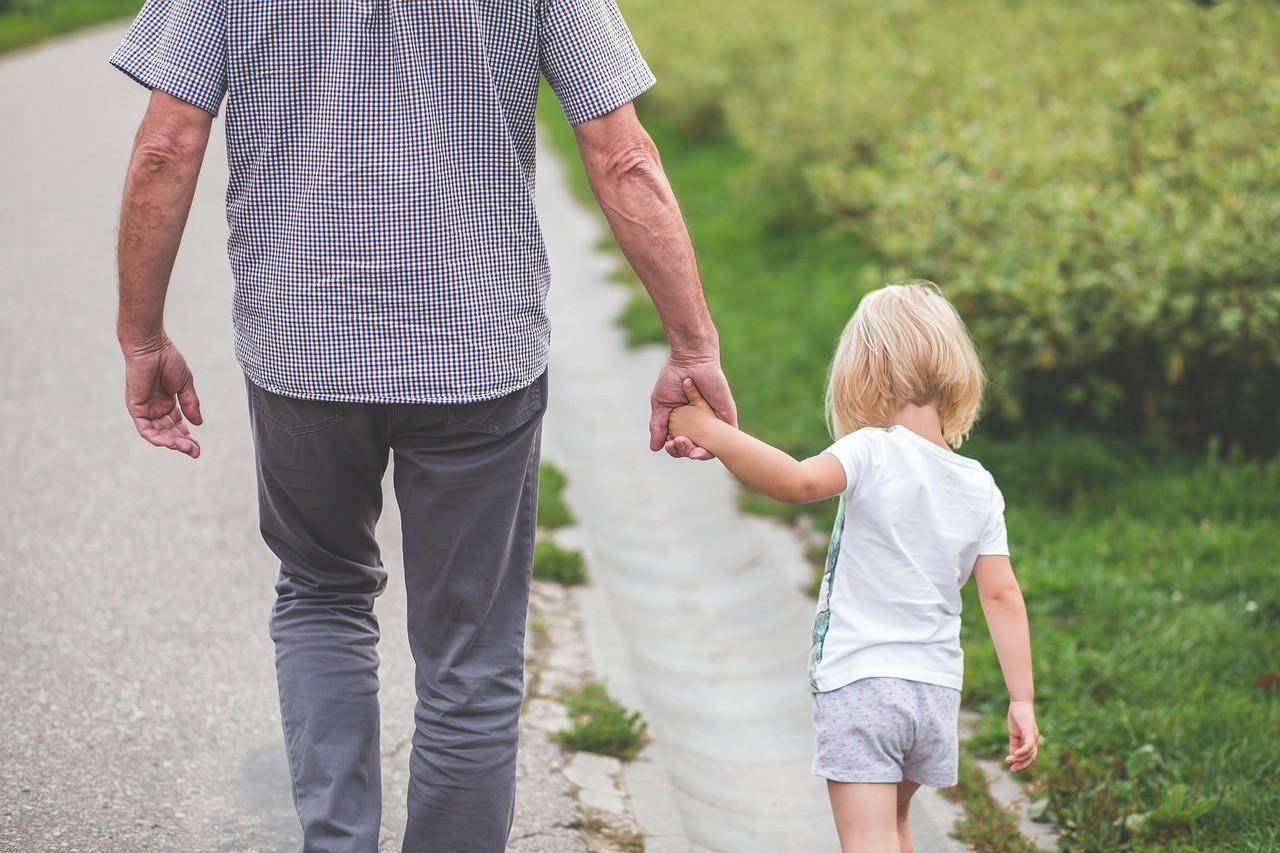 a grandfather holding his granddaughters hand