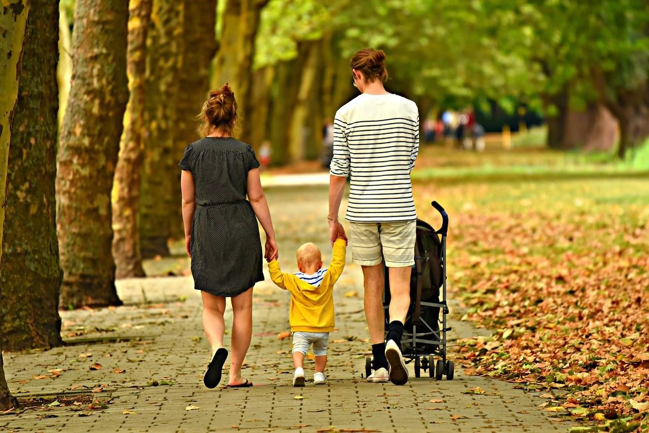 Family walking down their street with a stroller and toddler