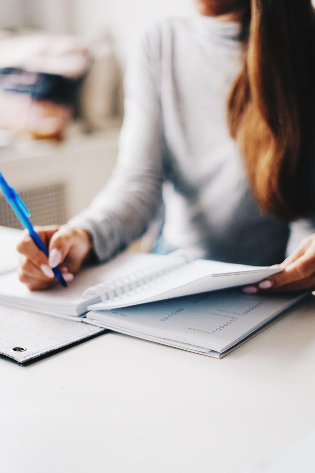 person writing in a planner