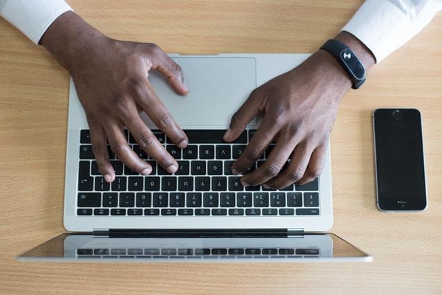 persons hands typing on a computer keyboard