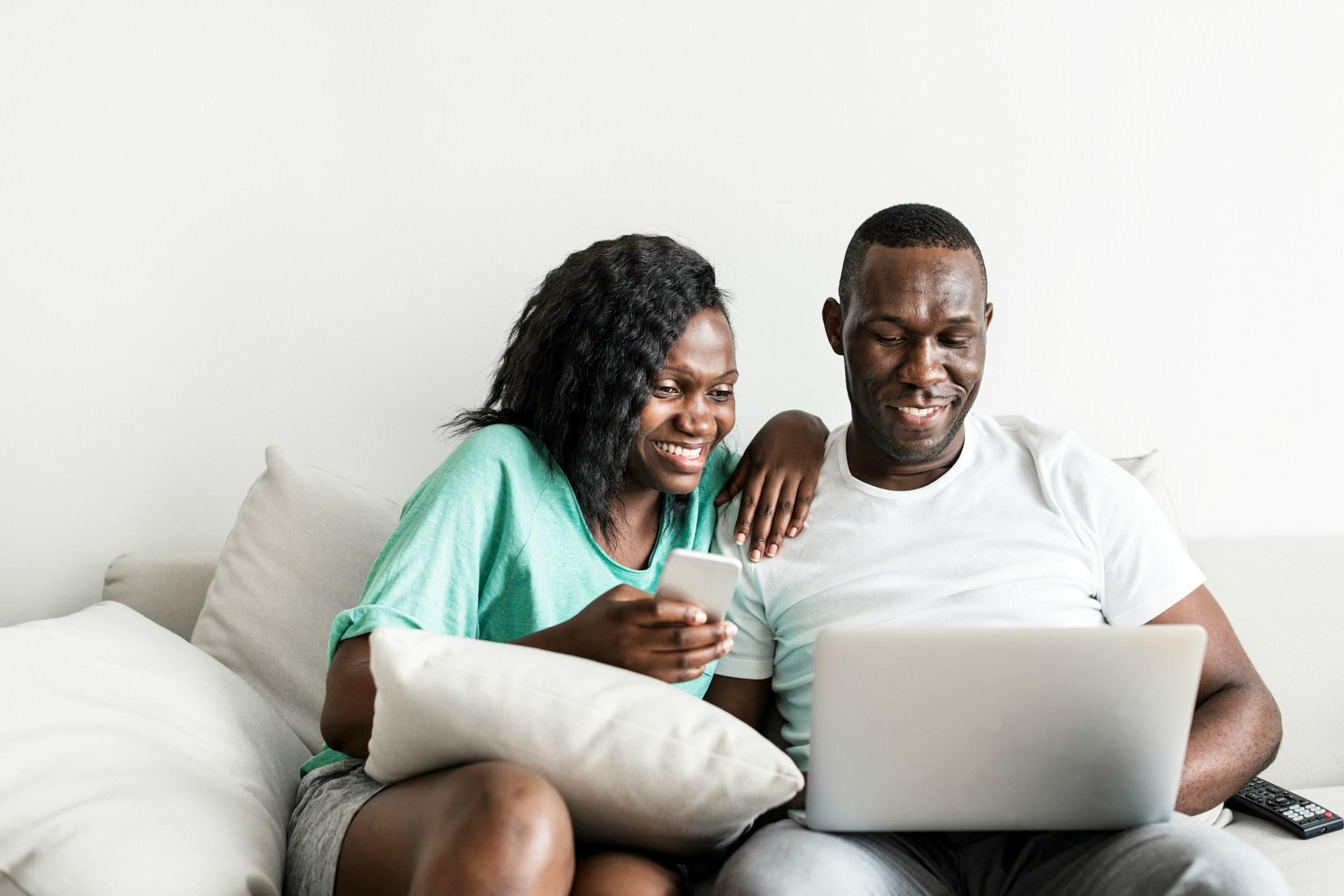 young couple on couch looking at laptop